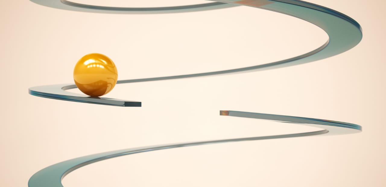 Golden sphere resting on a winding, metallic spiral track against a light background.