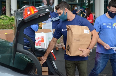 A Raymond James associate unloads food from car