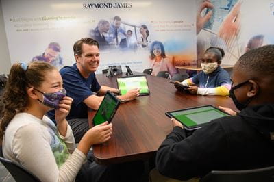 Patrick O'Connor sits at a table with three students