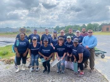 Memphis associates wearing Raymond James Cares shirts pose in the Alpha Omega garden