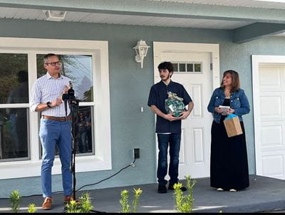 Kin Ginel presents the hammer to the Smith family