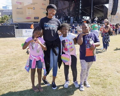 An adult mentor poses with her three young mentees